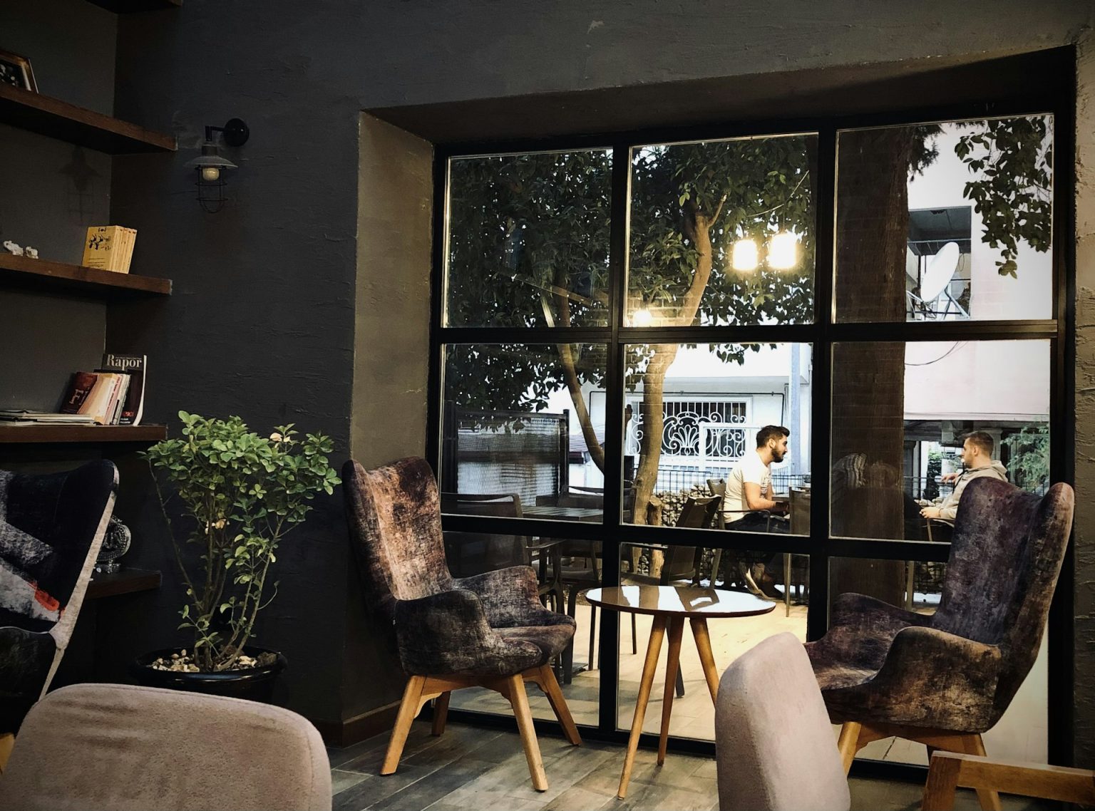 Guests relaxing by a sunny cafe window